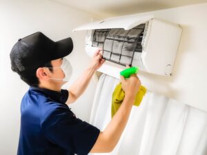 エアコンのフィルターを掃除する男性